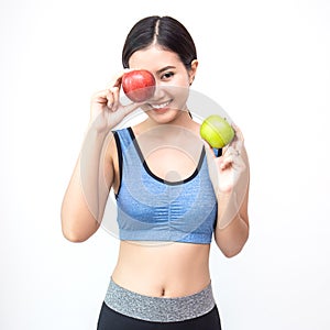 Young asian woman wearing sportwear holding red and green apple