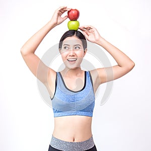 Young asian woman wearing sportwear holding red and green apple photo