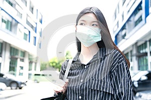 Young Asian woman wearing surgical mask during her commutation.