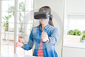 Young asian woman wearing virtual reality glasses smiling and concentrated playing video games of driving a car