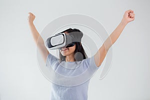 Young asian woman wearing vr headset playing game with excited in the bedroom at home.