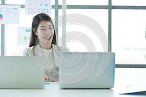 Young asian woman working at a call center Consulting about stock investment information with customers calling for advice