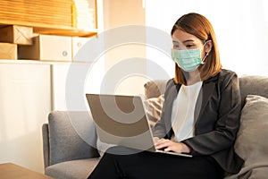 Young asian woman working from home using laptop