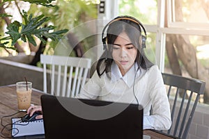 Young Asian woman working with laptop in coffee shop