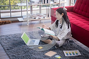 Young asian woman working with laptop computer in the living room.