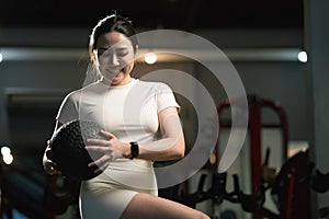 Young asian woman is working out with balls in gym