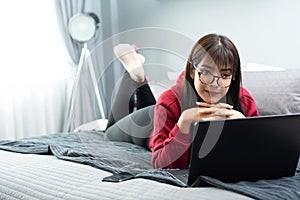 Young Asian woman works from home on tablet computer