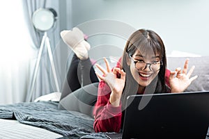 Young Asian woman works from home on tablet computer