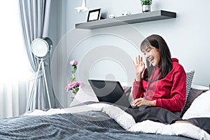 Young Asian woman works from home on tablet computer