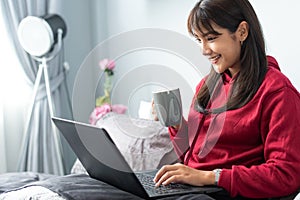 Young Asian woman works from home on tablet computer