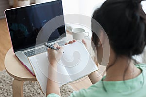 Young Asian woman writing on notebook