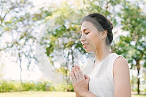 Young asian woman yoga outdoors keep calm and meditates while practicing yoga to explore the inner peace.