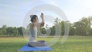 Young asian woman yoga outdoors keep calm and meditates while practicing yoga to explore the inner peace.