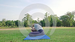 Young asian woman yoga outdoors keep calm and meditates while practicing yoga to explore the inner peace.