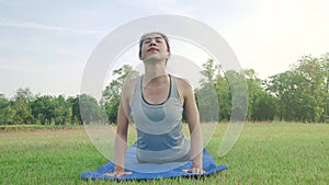 Young asian woman yoga outdoors keep calm and meditates while practicing yoga to explore the inner peace.