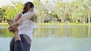 Young asian woman yoga outdoors keep calm and meditates while practicing yoga to explore the inner peace.