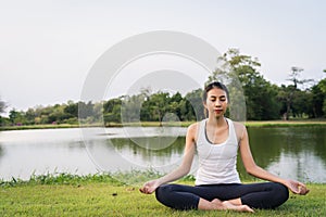 Young asian woman yoga outdoors keep calm and meditates while practicing yoga to explore the inner peace. Yoga have good benefits