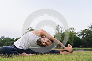 Young asian woman yoga outdoors keep calm and meditates while practicing yoga to explore the inner peace. Yoga have good benefits