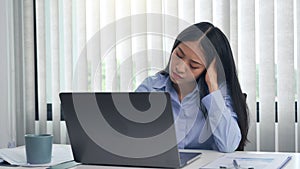 Young asian women are bored at work and feel lazy to deal with data on their laptop in the afternoon