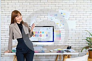 Young Asian Women graphic designer working with diagrams color and computer graphic at office