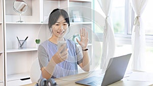 Young Asian women are greeting friends and teachers through video chats and greeting them with cheerful expressions