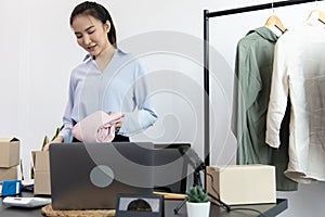Young Asian women pack their clothes into boxes and prepare them to be delivered by post, Online clothing sales business, Business