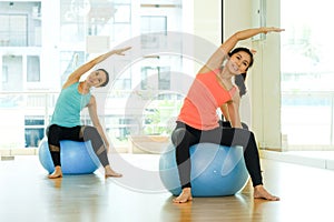 Young asian women practicing yoga ball, fitness stretching flexi
