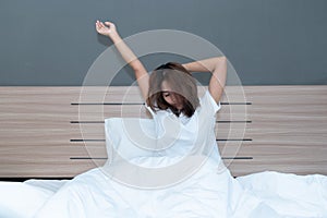 Young asian women stretching in bed after wake up