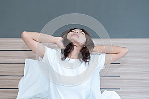 Young asian women stretching in bed after wake up