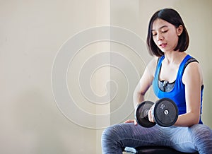 Asian woman training weight lifting at gym, photo