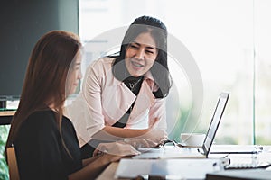 Young Asian women workers working together in office