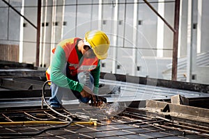 Young asian worker using machine welding iron with hands working in industrial factory.