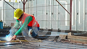 Young asian worker using machine welding iron with hands working in industrial factory, welder man or labor welding joint steel.