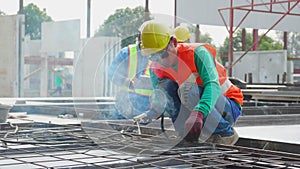 Young asian worker using machine welding iron with hands working while supervisor examining in industrial factory.