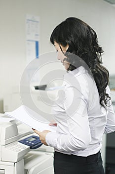 Young asian working with print photo
