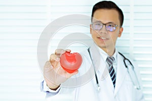Young Asians Doctor hand holding red heart. Health concept and heart disease symbol. selective focus. man and heart.on white