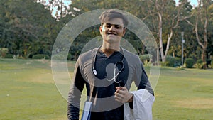 Young aspiring male doctor with a stethoscope on the neck standing in the park