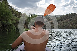 Young athlete sailing on the river with his kayak photo