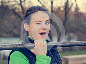 Young athlete effortlessly doing one-hand pullups.