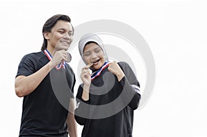 Young athlete holding medal and look excited after winning a game