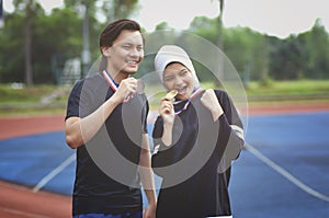Young athlete holding medal and look excited after winning a game
