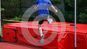 Young athlete jumping over a high jump bar