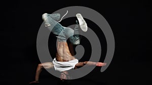 Young athlete man breakdancer with put on bike helmet actively head spins