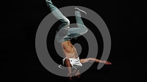 Young athlete man breakdancer with put on bike helmet actively spins on his head