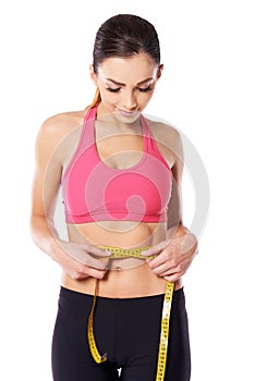 Young athlete measuring her waist