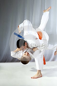 Young athlete with an orange belt performs technique nage-waza