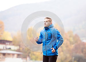 Young athlete in park running in colorful autumn nature