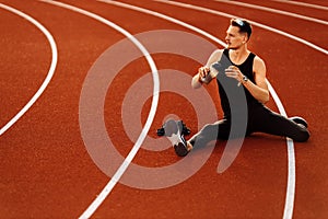 Young athlete resting after running in the stadium