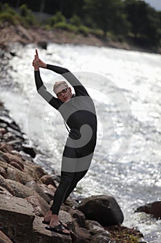 Young athlete on rocky beach prepearing to swim