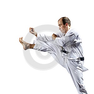 Young athlete strikes with a kick forward on a white background isolated